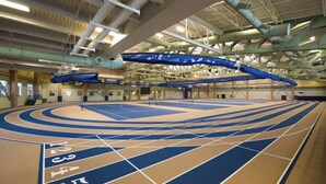 Eine Sporthalle mit einer Tartanbahn und Laufstegen an der Decke.