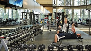 Ein Fitnessstudio mit verschiedenen Trainingsgeräten, darunter Kurzhanteln und Kraftmaschinen.