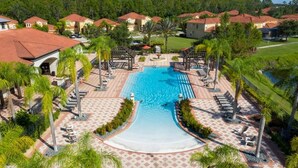 A resort with a large swimming pool, lounge areas, and a well-maintained landscape. - Remodeled Gem - Comfort and Location (Kissimmee)