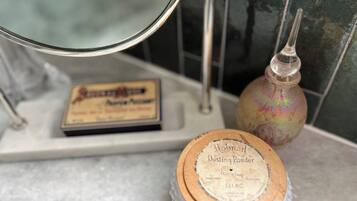 Ein hölzerner Behälter mit dem Aufdruck 'Hobnail Dusting Powder' auf einer Badezimmerablage.