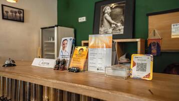 A reception desk with a sign for Urban Haven, a framed picture on the wall, and a QR code on the counter.