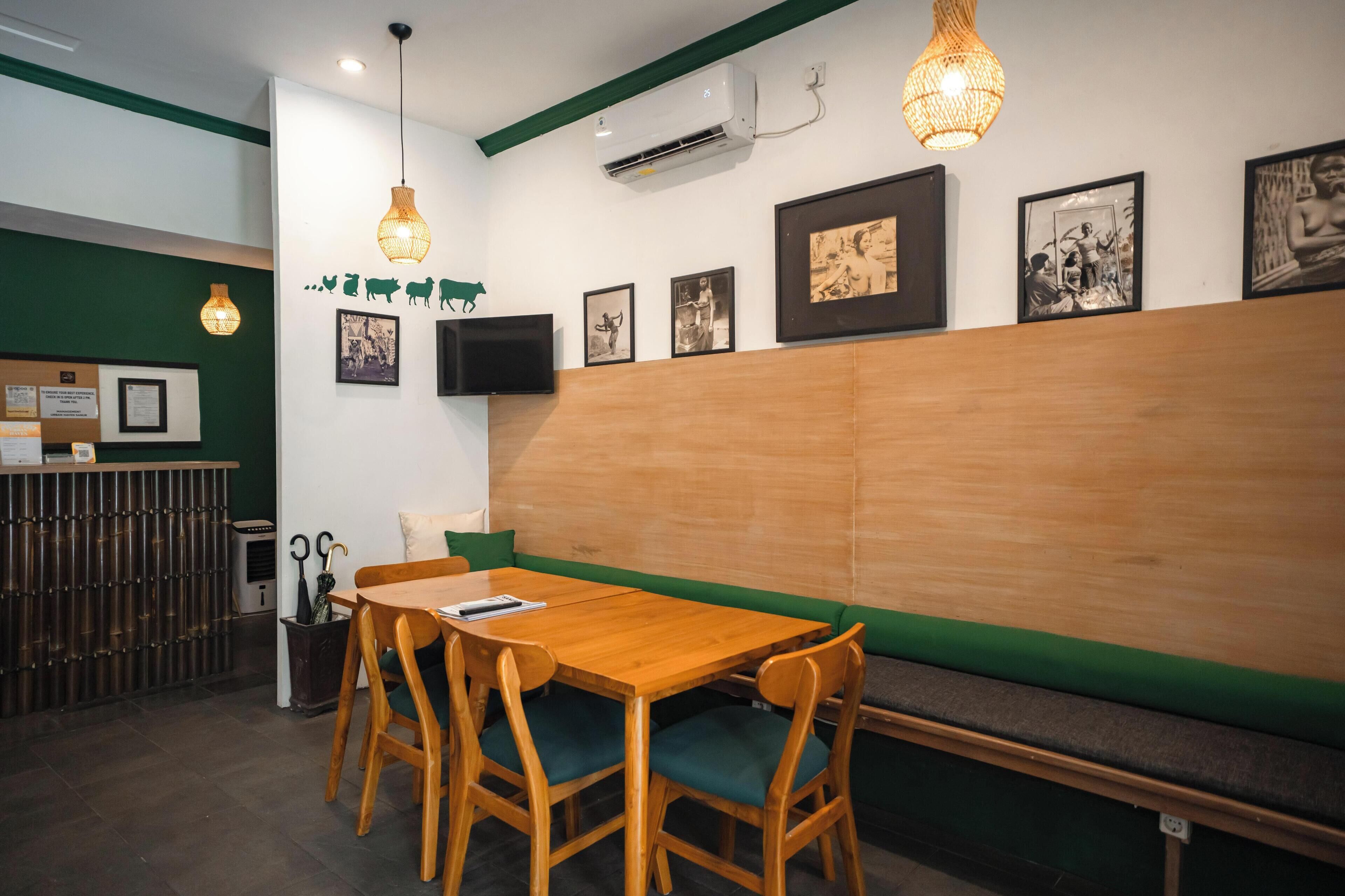 A restaurant interior with a wooden table and chairs, a bench, and wall-mounted artwork.