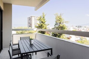 Enjoy the city view from this balcony with a table and chairs, perfect for taking in the sights.