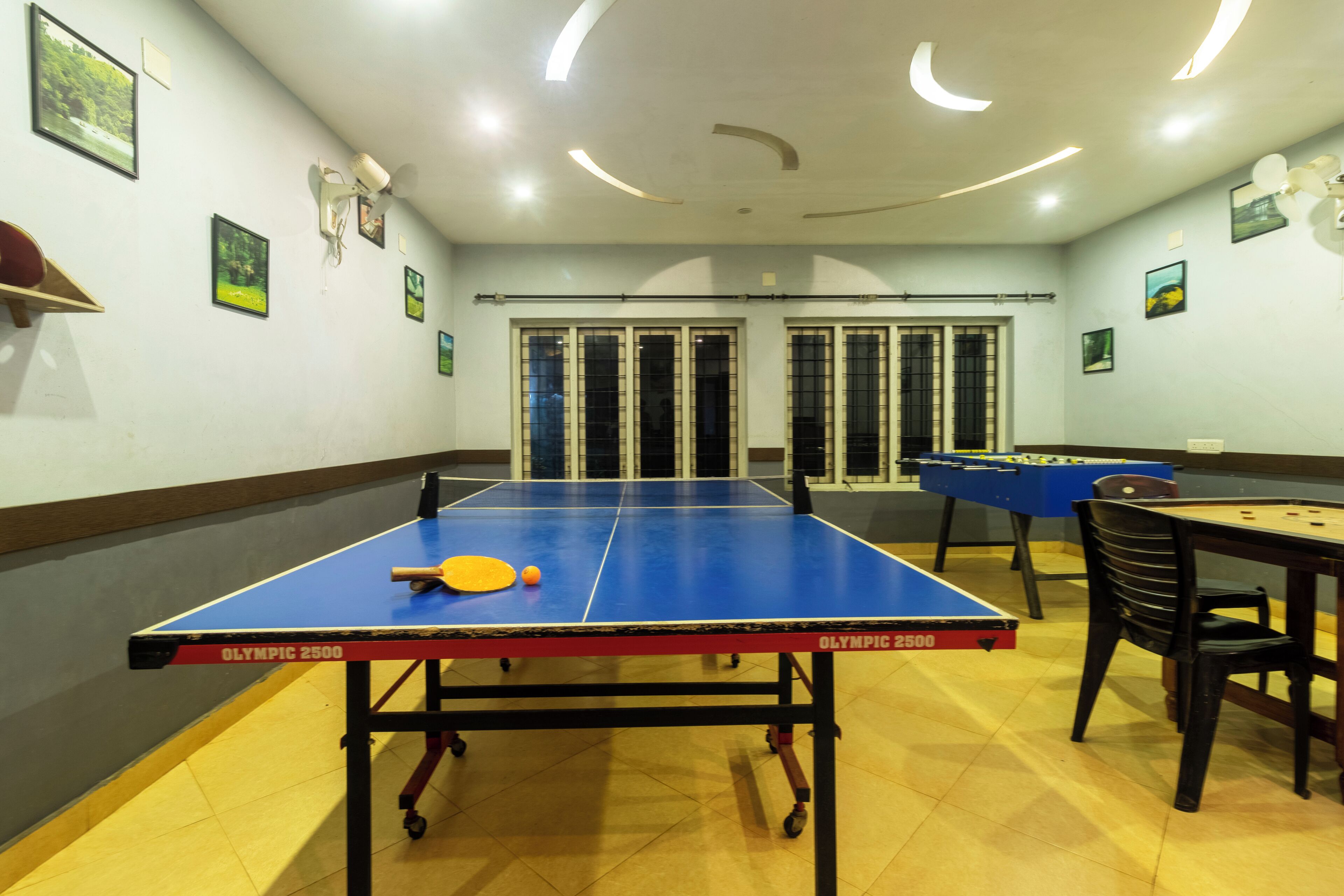 Une pièce équipée d’une table de ping-pong, d’un baby-foot et d’une table de billard.