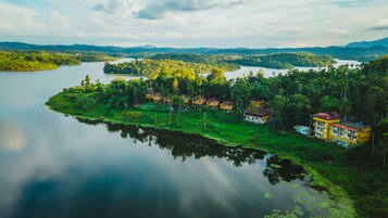 Una propiedad frente al lago con varias construcciones, abundante vegetación y un lago tranquilo.