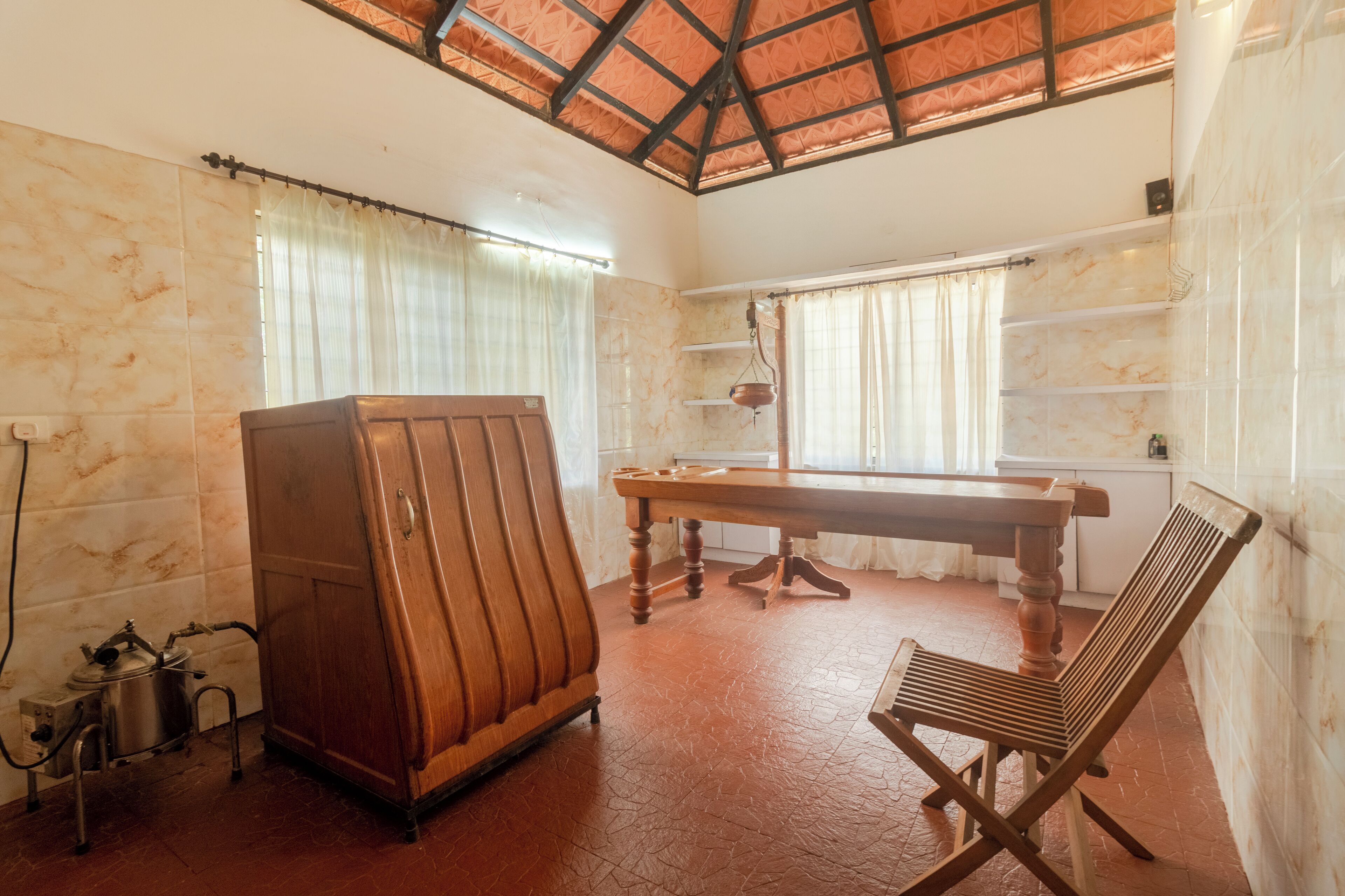 Una habitación con un armario de madera, una mesa y un banco.
