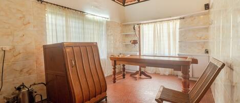 A room with a wooden cabinet, a table, and a bench.