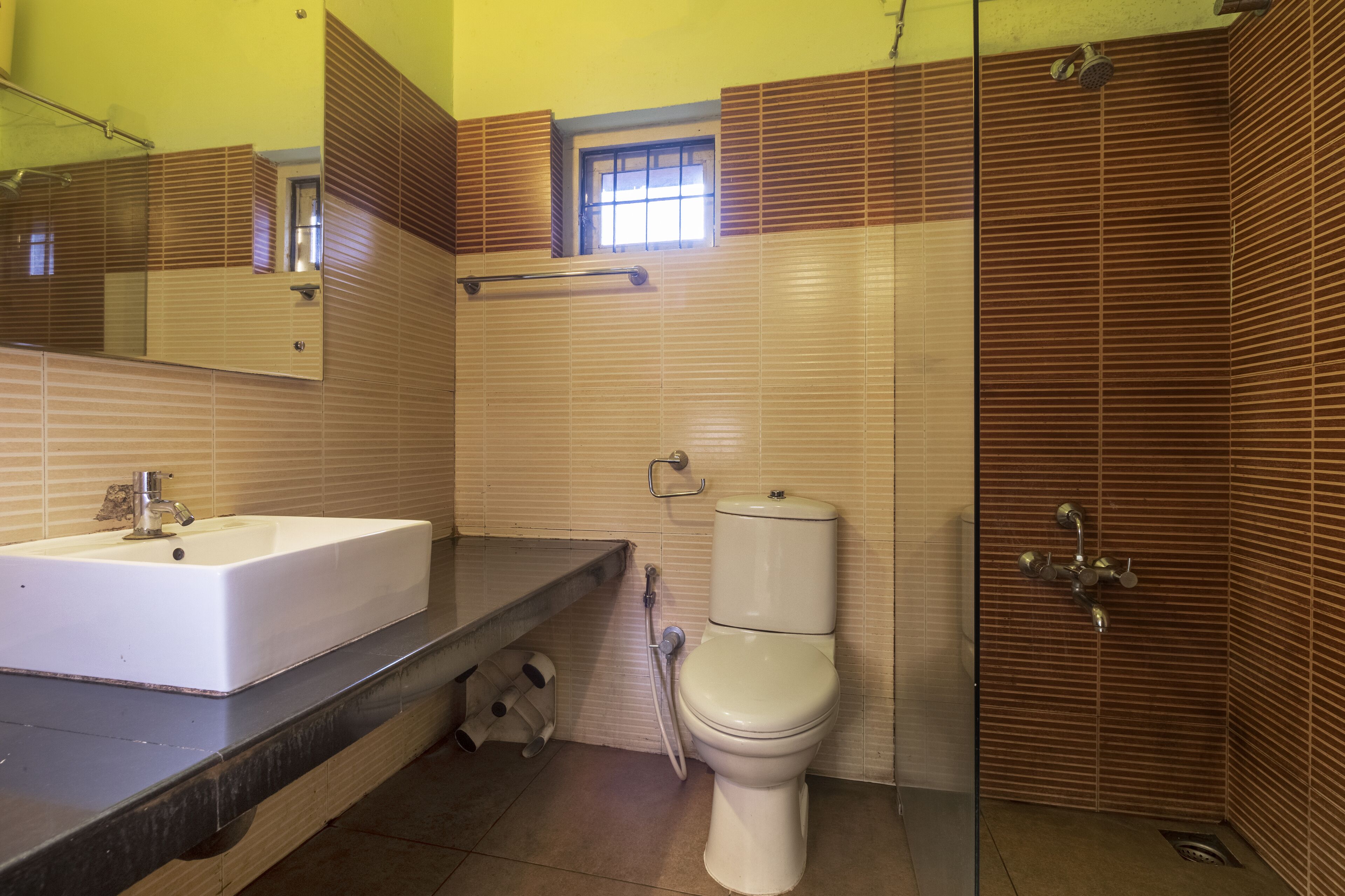 Une salle de bain avec un lavabo, des toilettes et une douche, le tout de couleur blanche.