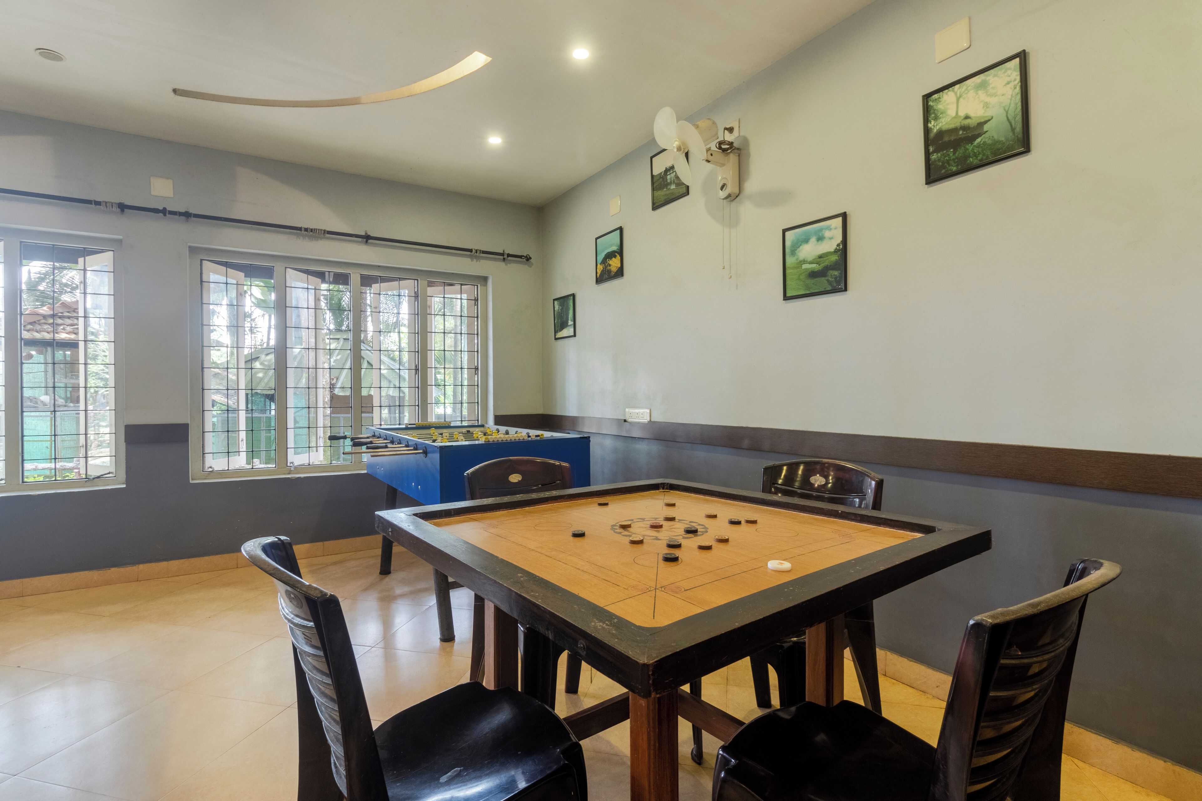 A room with a foosball table, several chairs, and a foosball table.