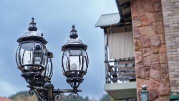 Two ornate street lamps with a stone building in the background.