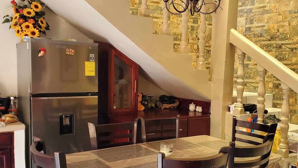 Un coin repas avec une table ronde, des chaises et un lustre.
