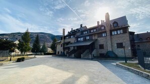 A large stone building with multiple levels and a spacious courtyard. - Apartamentos Linsoles (Benasque)