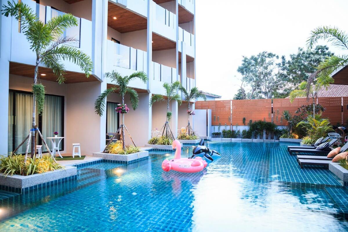 Ein Swimmingpool mit Liegestühlen und einem Flamingo-Schwimmpunkt.