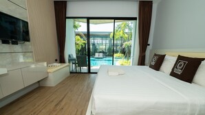 Une chambre d’hôtel moderne dotée d’un grand lit, d’une télévision, d’un petit coin salon et offrant une vue sur une piscine extérieure.