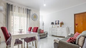 Ein Essbereich mit Tisch, Stühlen, einer Couch, einem Schrank und einer Tür.