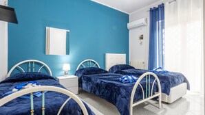 Ein Schlafzimmer mit zwei Betten, einem Nachttisch, einem Spiegel und einer Klimaanlage.