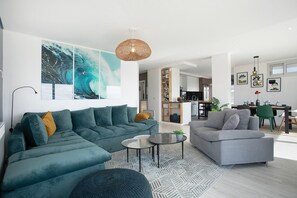 A modern living room with a sectional sofa, a grey armchair, and a coffee table.