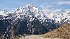 A mountain road with a guardrail, snow-covered peaks, and a clear sky. - Studio 'Les 2 Alpes' with Mountain View and Balcony (Les Deux Alpes)