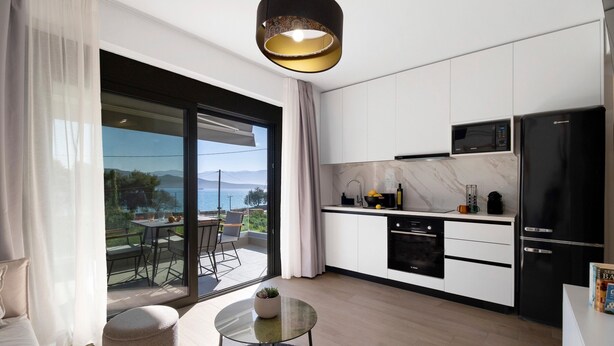 A modern kitchen with a large sliding glass door to a balcony, a black refrigerator, and a microwave. - Apartment 'Mella Roa Emer' with Sea View, Wi-Fi and Air Conditioning (???????)