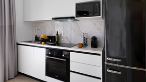A modern kitchen with a built-in microwave, a black refrigerator, and a Bosch dishwasher. - Apartment 'Mella Roa Emer' with Sea View, Wi-Fi and Air Conditioning (???????)