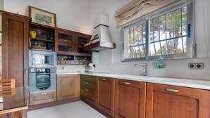 Une cuisine avec des meubles en bois, un four à micro-ondes, une cuisinière et une fenêtre donnant sur un beau paysage.