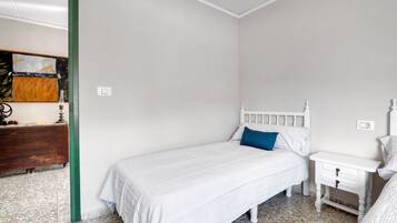 Une chambre à coucher avec un lit, une table de chevet, une commode et un chambranle de porte de couleur verte.