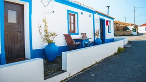 Un edificio blanco con detalles azules y una puerta marrón.