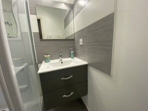 Bathroom features a sink, mirror, and cabinet with two drawers.