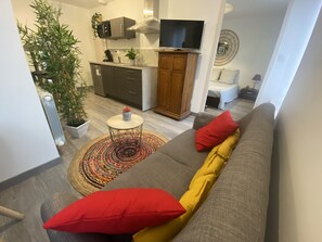 Relax in this stylish living space with a sofa, coffee table, and kitchen area.