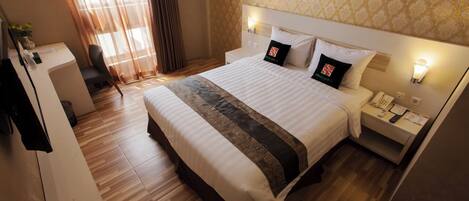 Una habitación de hotel con una cama grande, un escritorio y una silla.