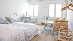 A bedroom with a bed, a table, chairs, and a radiator. - Lundsgaard Gods Badehotel (Kerteminde)