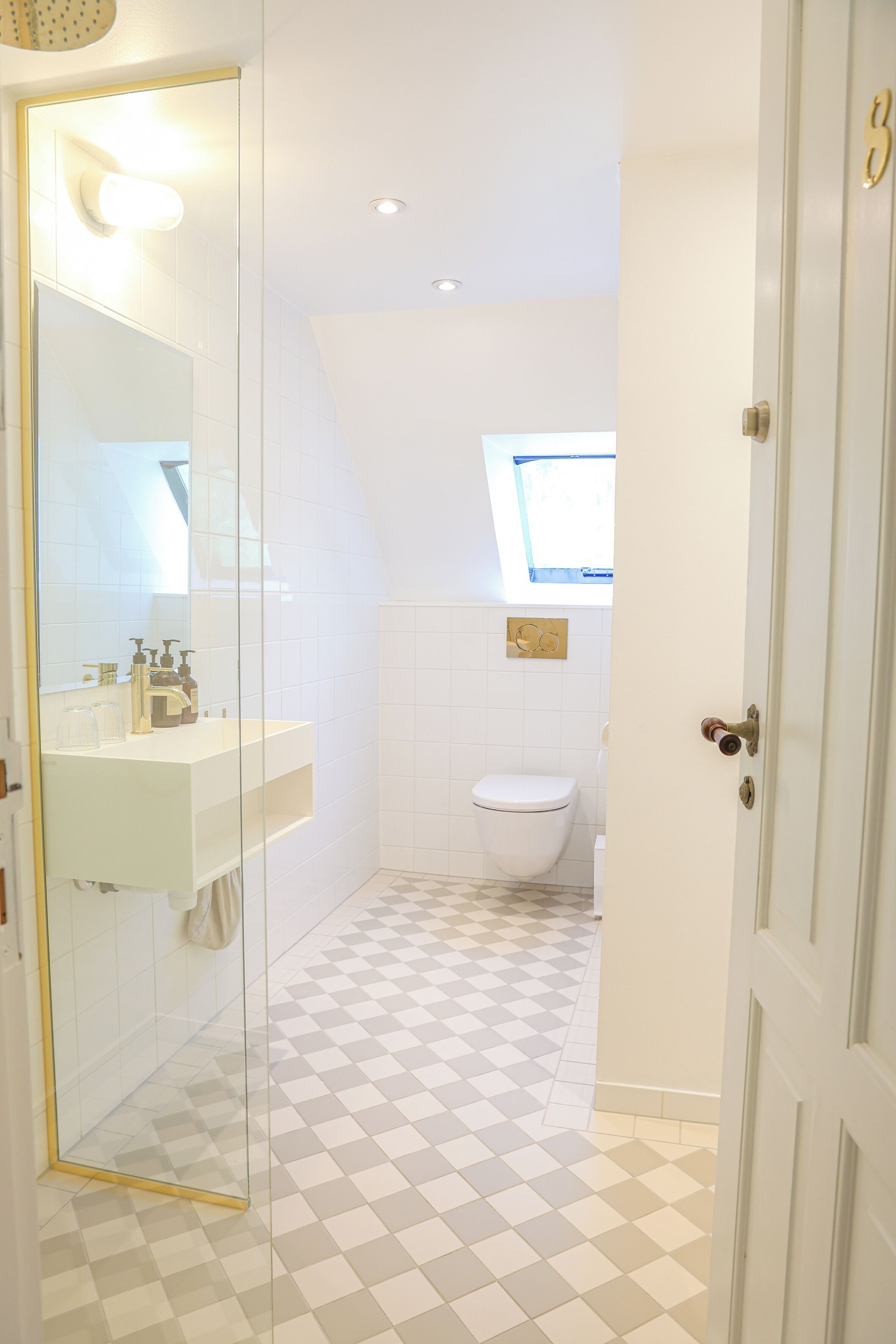 A bathroom with a glass shower enclosure, a white sink, and a toilet.