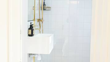Ein Badezimmer mit einem weißen Waschbecken, goldenen Armaturen und einem Schachbrettboden.