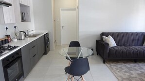 Una cocina moderna con comedor, un sofá y una puerta que da a otra habitación.