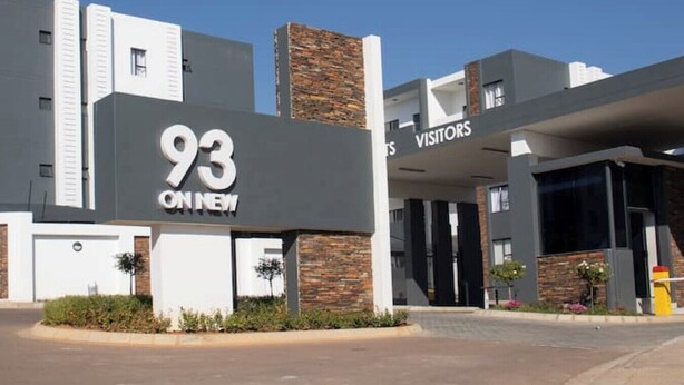 Un edificio moderno con un letrero llamativo que dice '93', indicando un hotel u otro establecimiento similar.