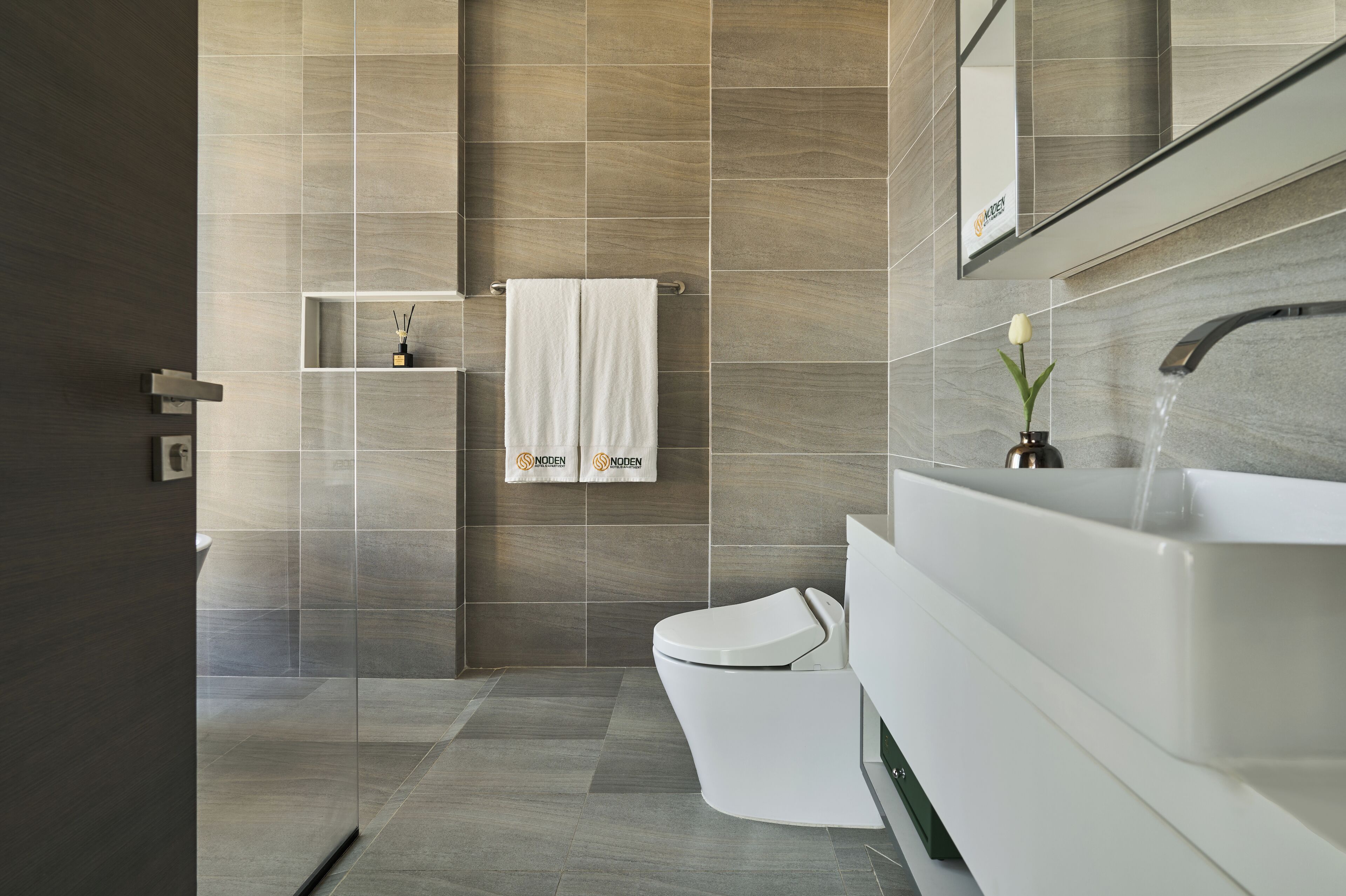 A modern bathroom with a large sink, a toilet, and a shower area.