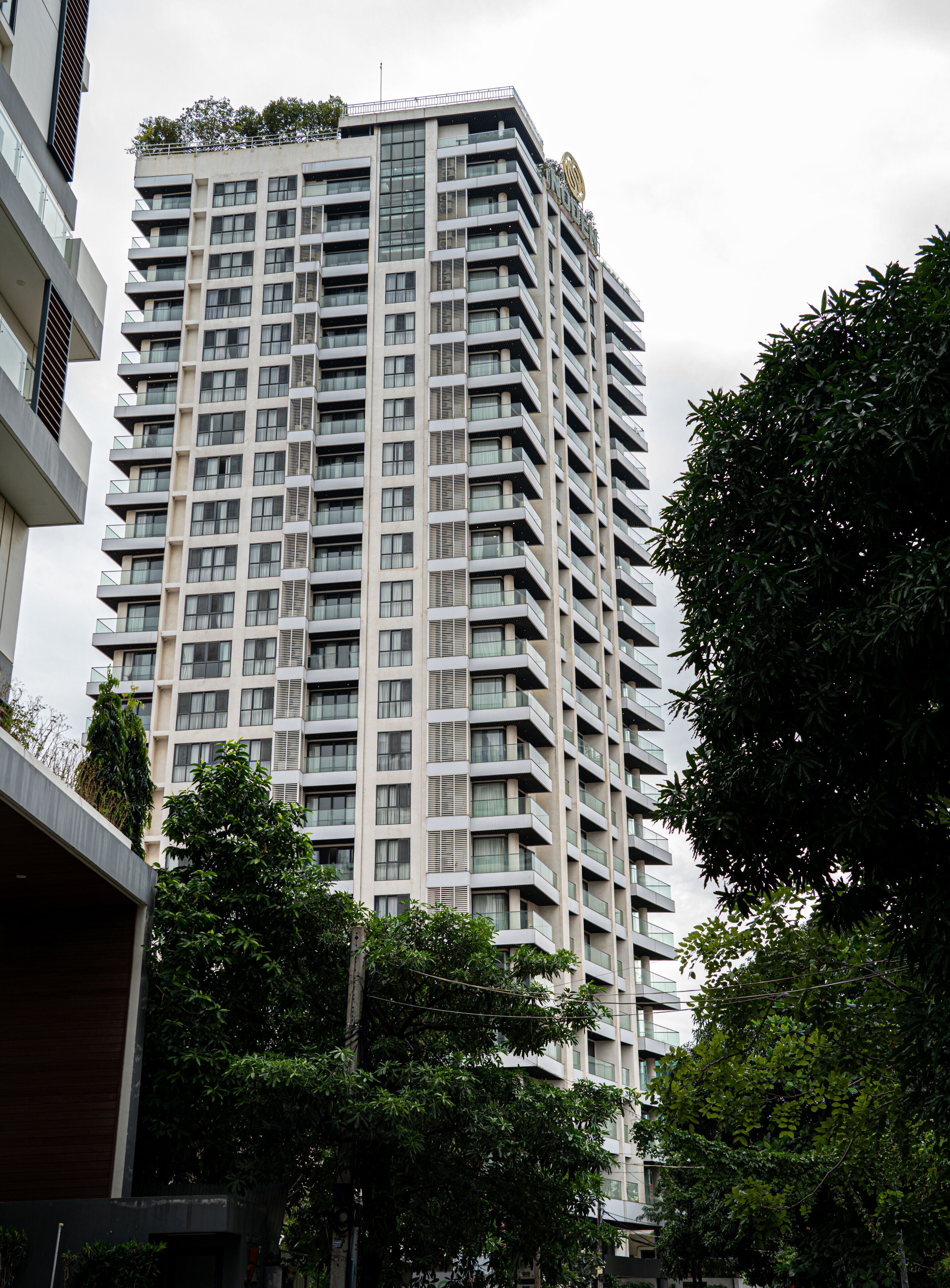 Um edifício alto com várias varandas, janelas grandes e um design arquitetônico moderno.