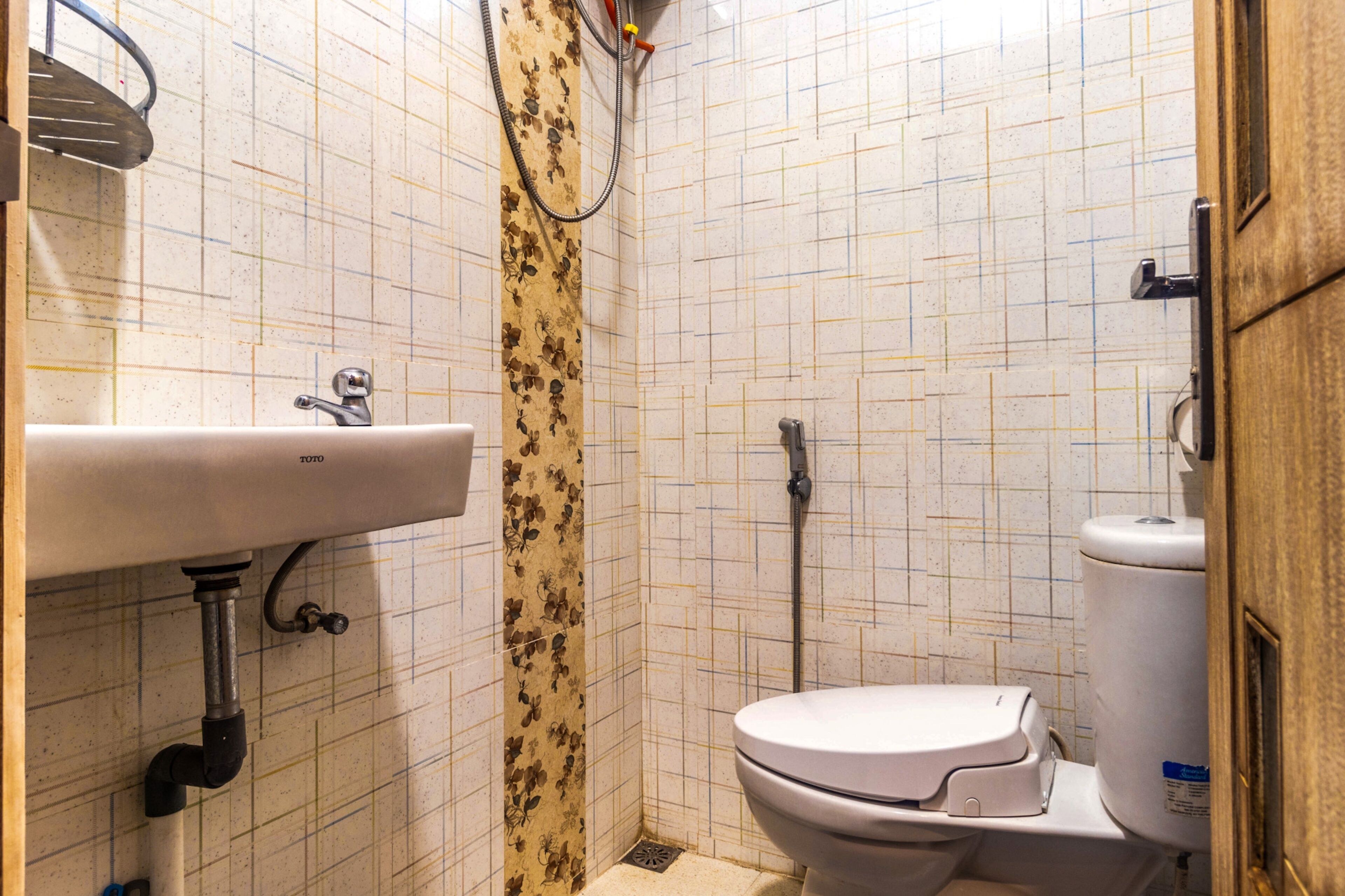 A small bathroom with a toilet, sink, and shower.