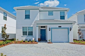 A two-story residential building with a blue door, a garage, and a number '4839' on the wall.