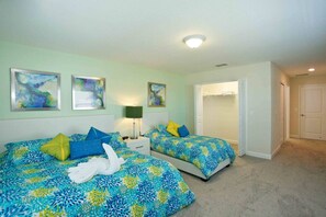 A bedroom with two beds, a nightstand, a lamp, and a closet. - Private Pool 5 bed/5 bath home inside Resort (Kissimmee)