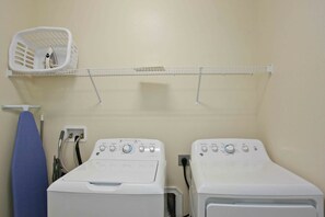 A laundry room with two washing machines, a drying rack, and a laundry basket. - Private Pool 5 bed/5 bath home inside Resort (Kissimmee)
