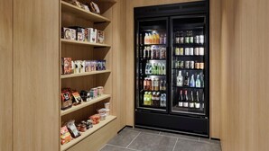 A storage area with wooden shelves and a black beverage refrigerator.