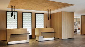 A reception area with two wooden reception desks, a wooden ceiling, and a tiled floor.