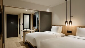 A modern hotel room with two beds, a wooden headboard, a bedside table, and a mirror. - Fairfield By Marriott Kumamoto Aso (Aso)