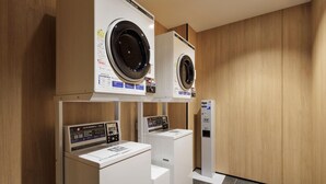 A laundry facility with two front-loading washing machines and a control panel. - Fairfield By Marriott Kumamoto Aso (Aso)