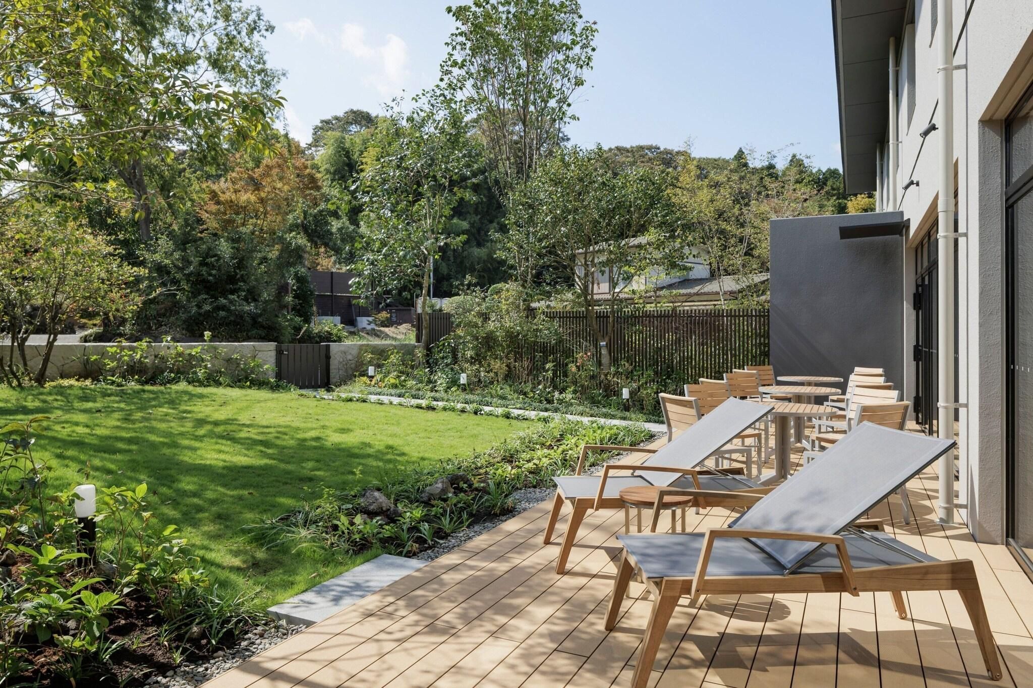 A patio with outdoor seating and a well-maintained lawn.