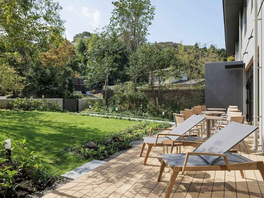 A patio with outdoor seating and a well-maintained lawn.