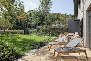 A patio with outdoor seating and a well-maintained lawn.