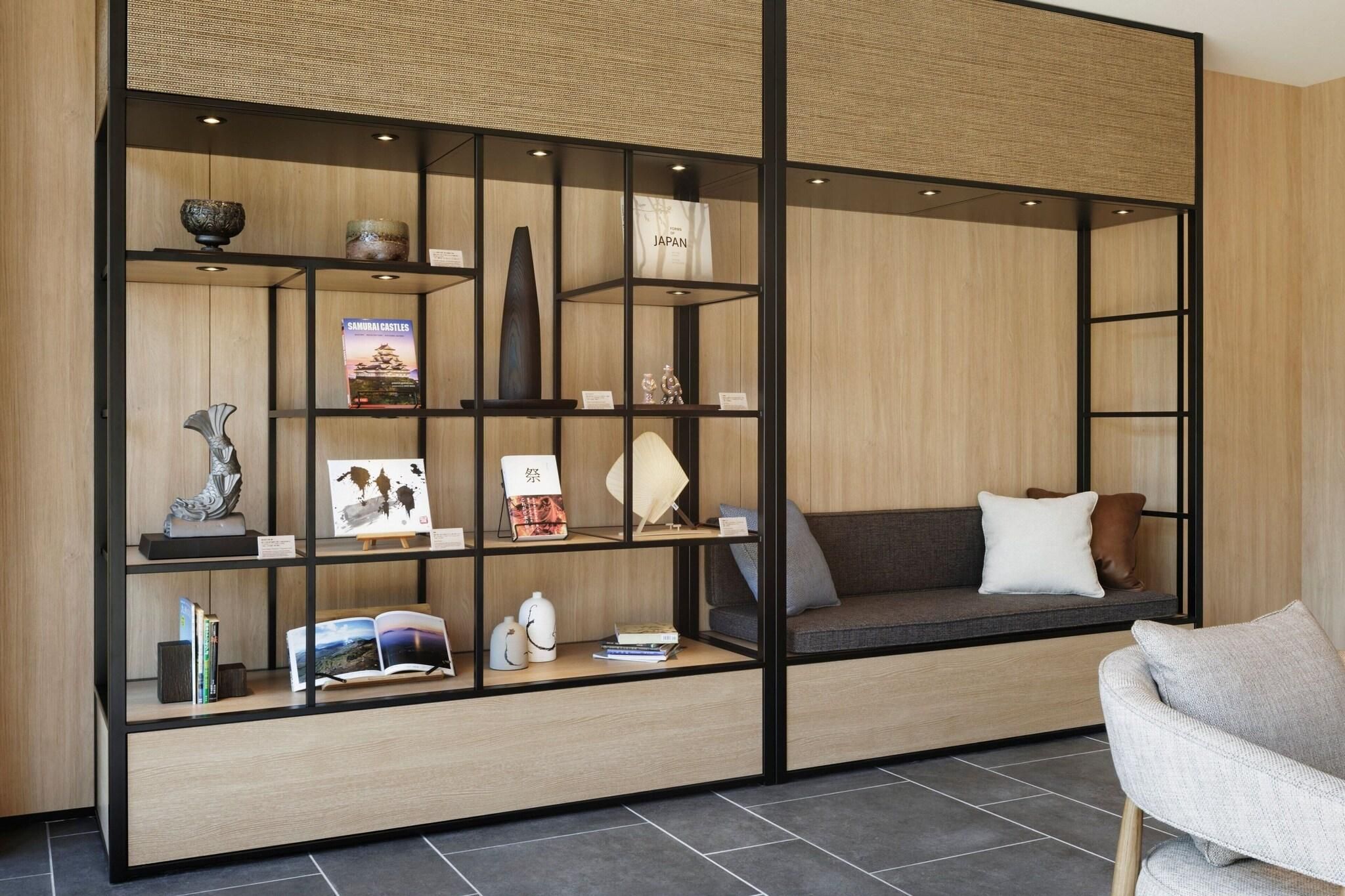 A modern interior with a built-in bookshelf, a cushioned seating area, and a small table.