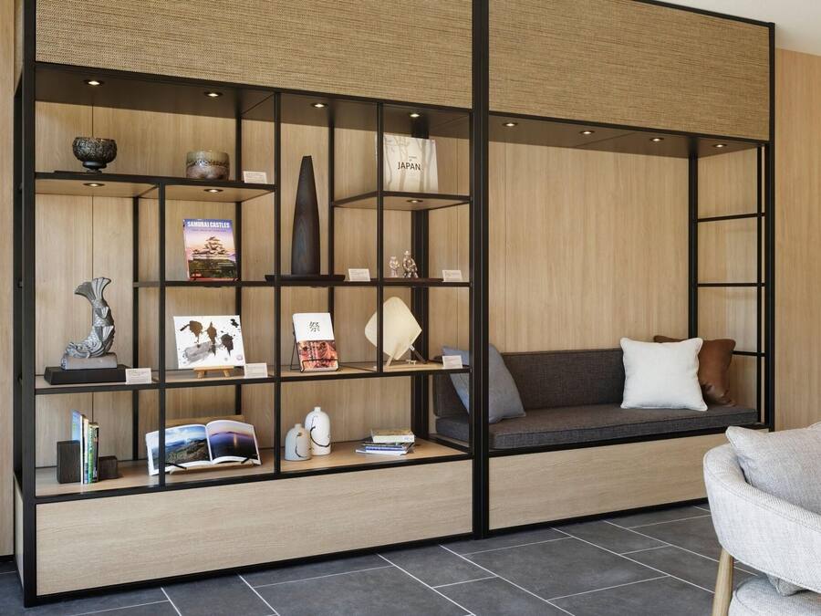 A modern interior with a built-in bookshelf, a cushioned seating area, and a small table.